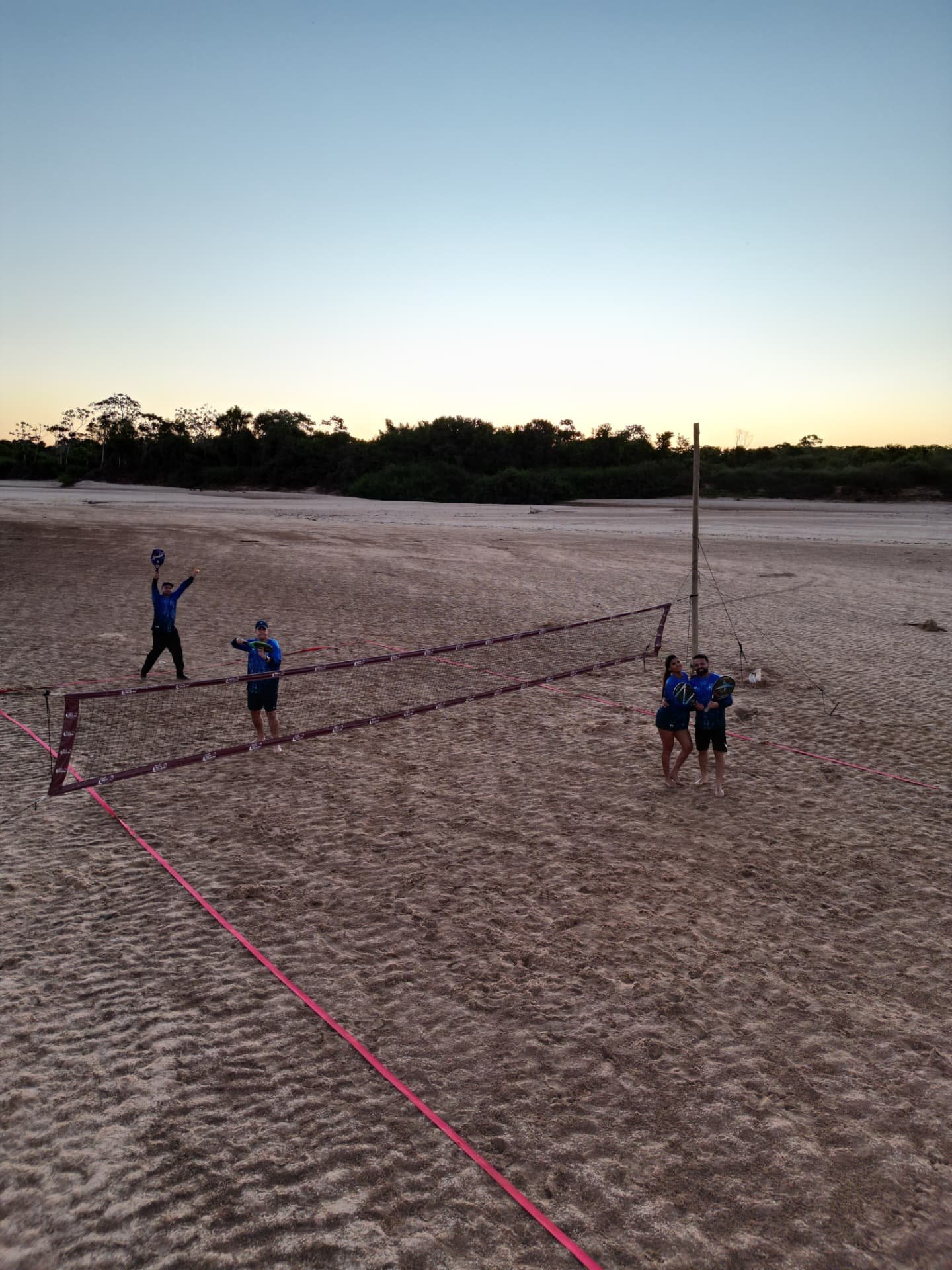 Hóspedes jogando beach tennis na praia do rio