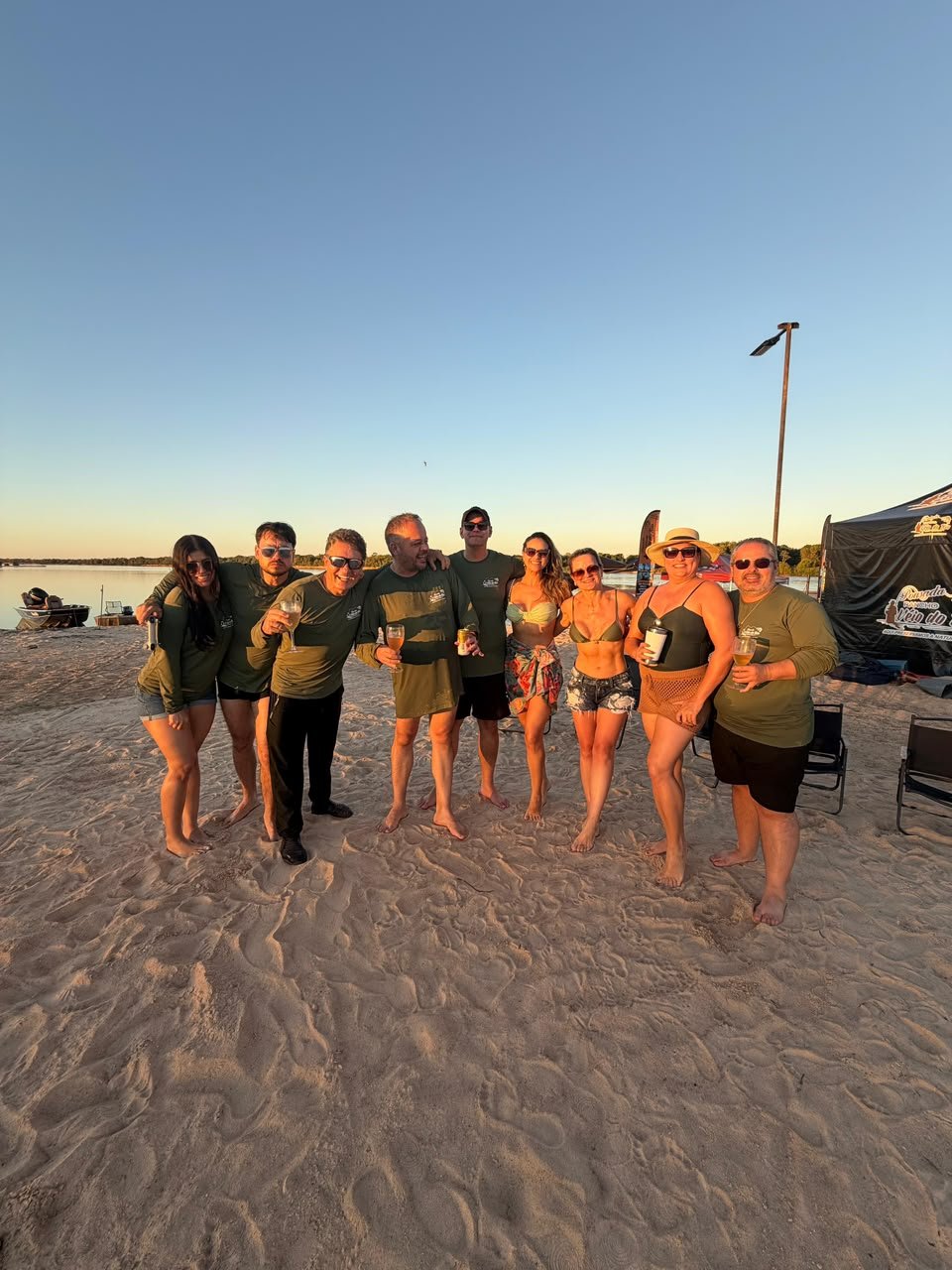 Grupo comemorando na faixa de areia do rio